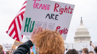 FILE - People attend a rally as part of a Transgender Day of Visibility, March 31, 2023, by the U.S. Capitol in Washington.