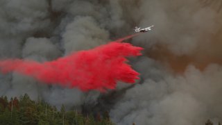 A plane drops fire retardant.