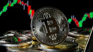 A visual representation of the digital cryptocurrency, Bitcoin, is on display in front of the Bitcoin course’s graph in Paris, February 9, 2021.