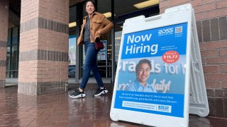 A customer walks by a now hiring sign posted in front of a Ross Dress For Less store on April 07, 2023 in Novato, California.