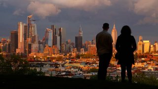 The sun sets on the skyline of midtown Manhattan and the Empire State Building in New York City, as seen from Jersey City, New Jersey, April 23, 2023.