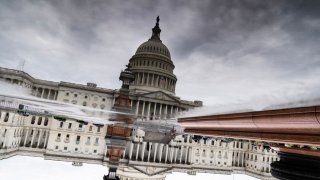 An inverted image of the U.S. Capitol is reflected in puddle on the East Front on Tuesday, May 9, 2023. (Tom Williams/CQ-Roll Call, Inc via Getty Images)