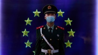 A member of the Peoples Armed Police stands guard in front of the flag of the European Union at the European Delegation in Beijing, China.