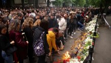 School children gather to light candles for the victims near the Vladislav Ribnikar school in Belgrade, Serbia, Thursday, May 4, 2023.