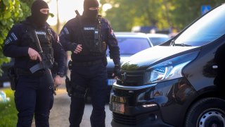 Police officers block the street near the scene of a Thursday night attack in the village of Dubona, some 50 kilometers (30 miles) south of Belgrade, Serbia, Friday, May 5, 2023. A shooter killed multiple people and wounded more in a drive-by attack late Thursday in Serbia’s second such mass killing in two days, state television reported.