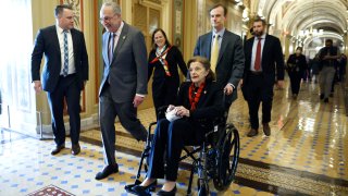 Senate Majority Leader Charles Schumer escorts Sen. Dianne Feinstein.