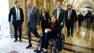 Senate Majority Leader Charles Schumer escorts Sen. Dianne Feinstein.