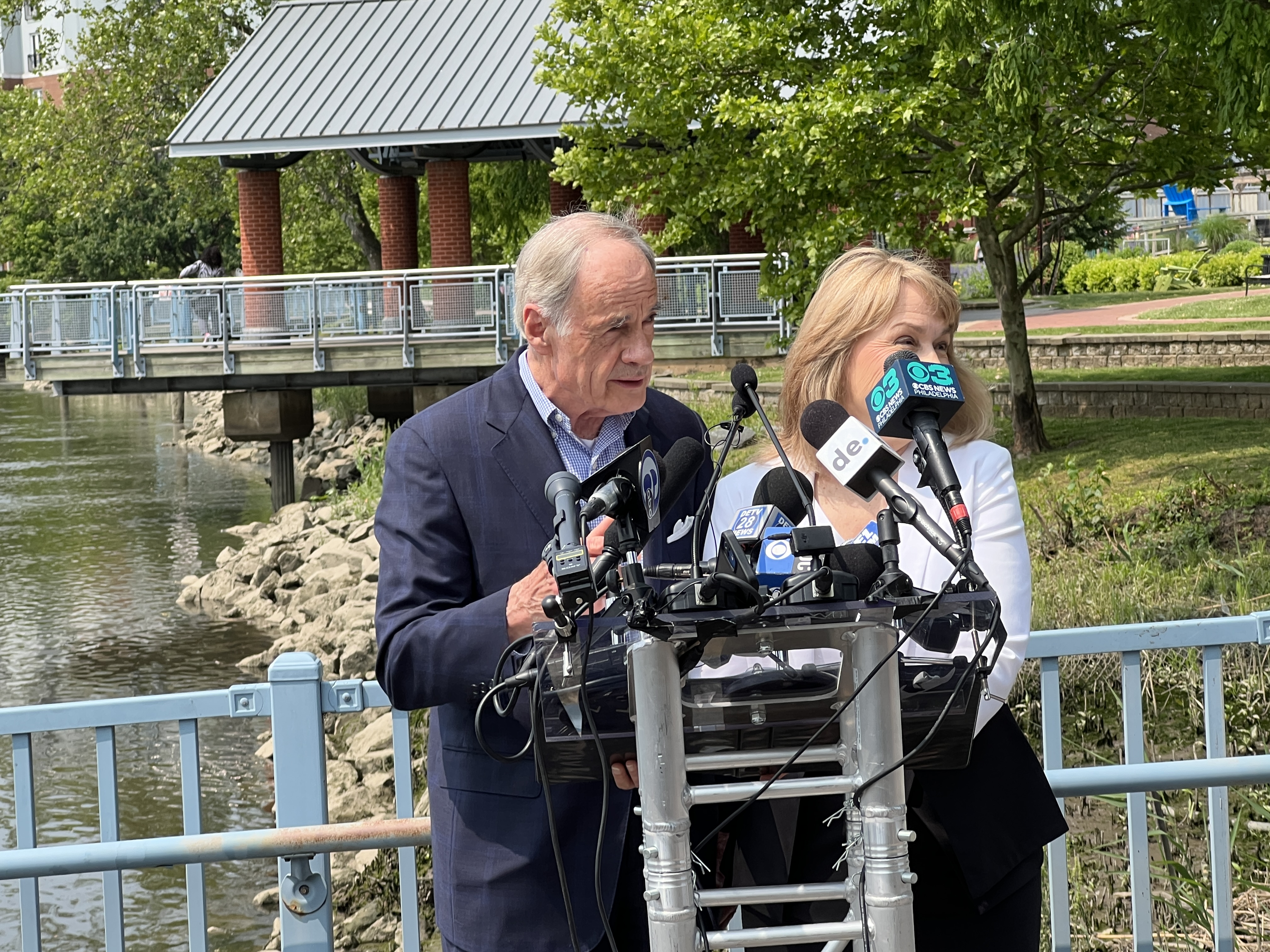 Tom Carper stands next to wife behind microphones