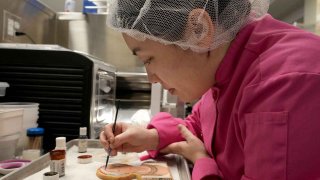 Jasmine Cho carefully paints her cookie, often honoring Asian Americans.