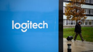 A man walks by a panel with the logo of Logitech on the campus of the Swiss Federal Institute of Technology of Lausanne in Lausanne, Switzerland, Nov. 27, 2019.