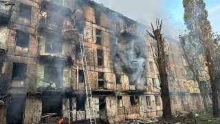 In this photo released by Dnipro Regional Administration, emergency workers extinguish a fire after missiles hit a multi-story apartment building in Kryvyi Rih, Ukraine, Tuesday, June 13, 2023.