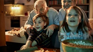 grandparents watching a movie together with their grandchildren