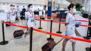 Flight attendants prepare to board a plane at Haikou Meilan International Airport on March 17, 2023 in Haikou, Hainan Province of China.