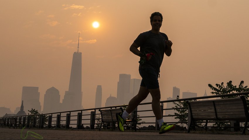 The One World Trade Center and the New York skyline is seen in the background as a man jogs through the Liberty State Park while the smoke from Canada wildfires covers the Manhattan borough on June 8, 2023 in New Jersey. (Photo by Eduardo Munoz Alvarez/Getty Images)