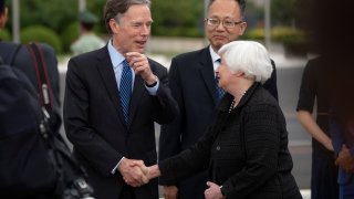U.S. Treasury Secretary Janet Yellen (R) shakes hands with U.S. Ambassador to China Nicholas Burns (L) on her arrival in Beijing on July 6, 2023, as Yang Yingming, Director General of the Department of International Economic Relations of China’s Ministry of Finance, looks on.