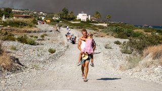 Tourists are evacuated as huge wildfire rages across Greece’s Rhodes island on July 22, 2023.