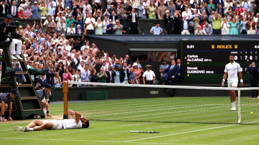 Carlos Alcaraz of Spain celebrates winning Championship Point as Novak Djokovic of Serbia looks dejected in the Men’s Singles Final on day fourteen of The Championships Wimbledon 2023 at All England Lawn Tennis and Croquet Club on July 16, 2023 in London, England.