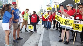 Striking WGA (Writers Guild of America) workers, in blue shirts, gather and speak in solidarity on a picket line with striking hotel workers of Unite Here Local 11 outside the Ritz-Carlton hotel on July 3, 2023 in Los Angeles, California.