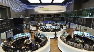 Traders sit at their desk at the Frankfurt Stock Exchange.