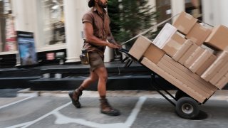 Carlos, a UPS worker in Manhattan, delivers packages on his daily rounds on July 24, 2023 in New York City.