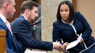 Fulton County District Attorney Fani Willis, right, talks with a member of her team during proceedings to seat a special purpose grand jury in Fulton County, Georgia, on May 2, 2022, to look into the actions of former President Donald Trump and his supporters who tried to overturn the results of the 2020 election.