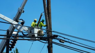 Linemen work on poles Aug. 13, 2023, in Lahaina, Hawaii,