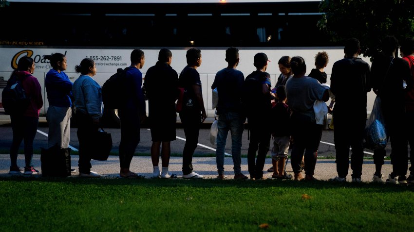 Migrants, who boarded a bus in Texas, listen to volunteers offering assistance after being dropped off within view of the US Capitol building in Washington, DC, on August 11, 2022. – Since April, Texas Governor Greg Abbott has ordered buses to carry thousands of migrants from Texas to Washington, DC, and New York City to highlight criticisms of US President Joe Bidens border policy. (Photo by Stefani Reynolds / AFP) (Photo by STEFANI REYNOLDS/AFP via Getty Images)