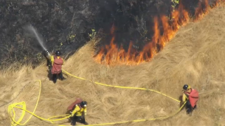 Firefighters battle a brush fire in Hayward.