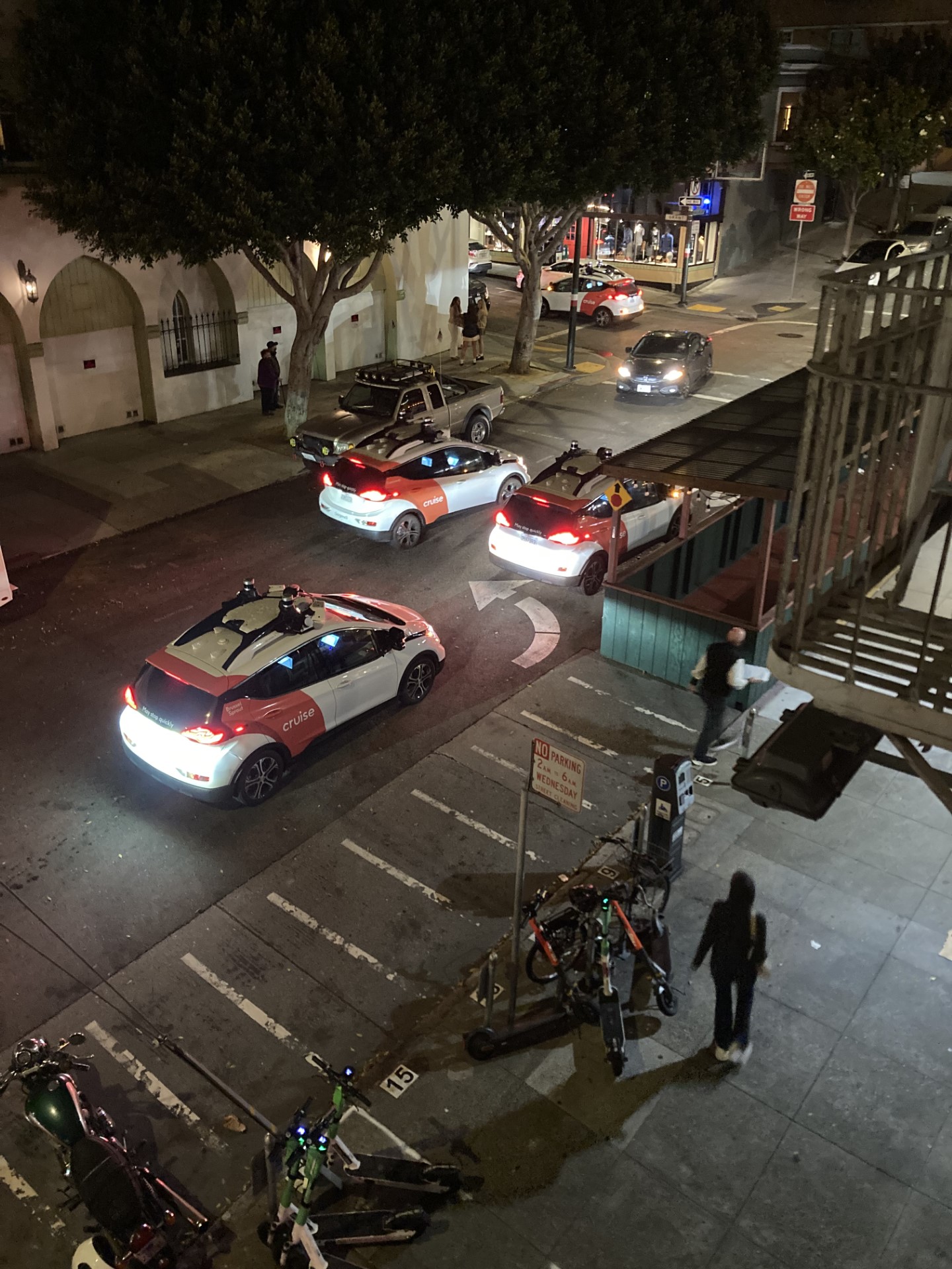 Cell phone image overlooking a San Francisco Street at nighttime showing several Cruise robotaxis stopped on Vallejo Street in San Francisco's North Beach.