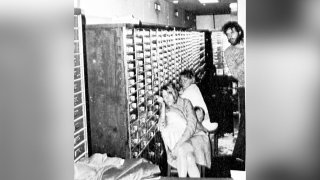 FILE – In this photo released by police, three of the four hostages and bank robber Clark Olofsson, standing right, are seen in a bank in Stockholm, Sweden, Aug. 27, 1973, shortly before the gunmen were overwhelmed by police.