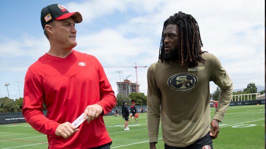 Brandon Aiyuk chats with 49ers general manager John Lynch during training camp.