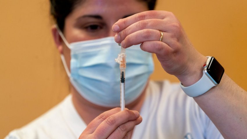 A health-care worker prepares a dose of the Pfizer-BioNTech Covid-19 vaccine at a vaccination clinic in the Peabody Institute Library in Peabody, Massachusetts, Jan. 26, 2022.