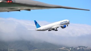 A United Airlines plane takes off as the Air Force One planeâs wing is seen at San Francisco International Airport in San Francisco, June 21, 2023.