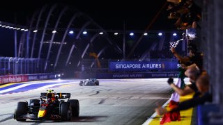 Race winner Sergio Perez of Mexico passes his team celebrating during the F1 Grand Prix of Singapore at Marina Bay Street Circuit on October 02, 2022 in Singapore