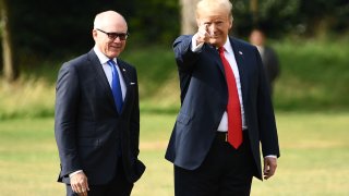 US President Donald Trump (R) gestures as he talks with US Ambassador to the United Kingdom Woody Johnson (L) preparing to board Marine One to depart the US ambassador’s residence Winfield House in London on July 13, 2018.