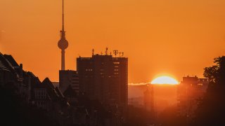 The victory column and TV tower are pictured in front of the sunrise in Berlin, Germany.