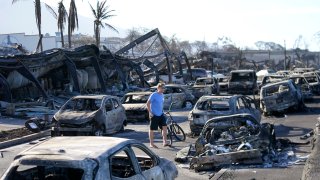 FILE - A man walks through wildfire wreckage Aug. 11, 2023, in Lahaina, Hawaii.