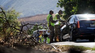 Members of the Hawaii National Guard check on a car passing the checkpoint on Kaniau Road