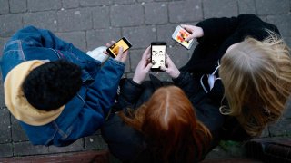 Group of friends on their phones shot form above in the fading light.