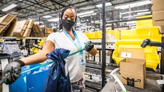 An Amazon.com Inc worker prepares an order in which the buyer asked for an item to be gift wrapped at a fulfillment center in Shakopee, Minnesota, U.S., November 12, 2020.