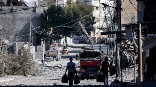 Palestinians with their belongings flee to safer areas in Gaza City after Israeli air strikes, on Oct.13, 2023.