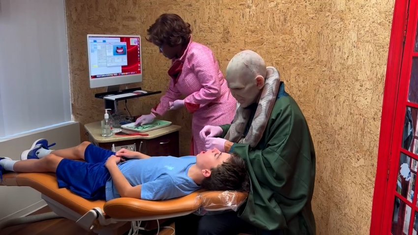 An orthodontist dressed as Lord Voldemort treats a patient.