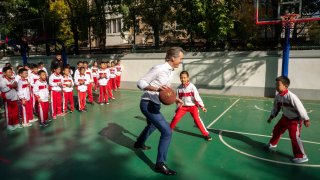 California Gov. Gavin Newsom plays basketball with children during his visit to China.