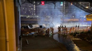 In this image made available by Italian State Police, Italian state police agents attend the scene of a passenger bus accident near the city of Venice, Italy, that fell from an elevated road, late Tuesday, Oct. 3, 2023.