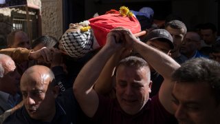 Mourners carry the body of Sohaib al-Soos, 15, during his funeral in the West Bank city of Ramallah