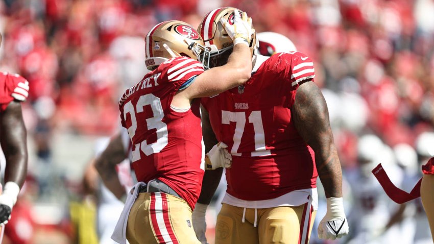 Christian McCaffrey and Trent Williams hug