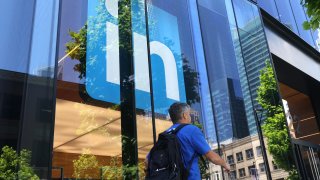 A pedestrian walks by a sign at a LinkedIn office on July 26, 2023 in San Francisco, California.