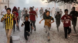 Palestinian children run as they flee from Israeli bombardment in Rafah in the southern Gaza Strip on November 6, 2023, amid continuing battles between Israel and the Palestinian militant group Hamas.