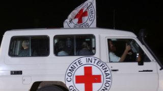 A Red Cross vehicle, as part of a convoy believed to be carrying hostages abducted by Hamas militants during the October 7 attack on Israel, arrives at the Rafah border, amid a hostages-prisoners swap deal between Hamas and Israel, as seen from southern Gaza Strip November 24, 2023.