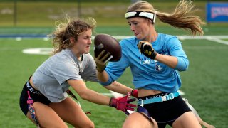 Two women play flag football